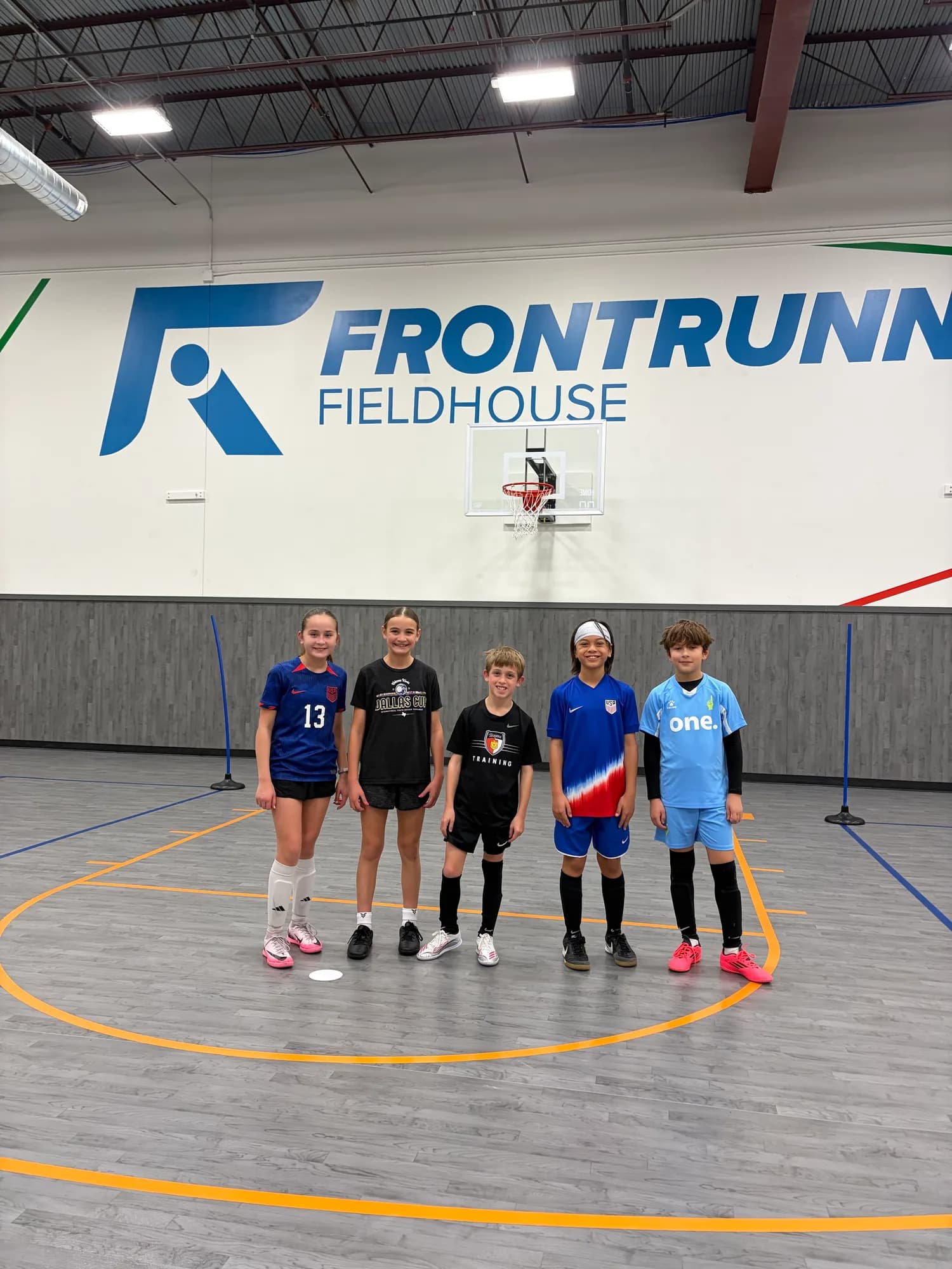 Kids in Frontrunner Fieldhouse shirts on the indoor courts