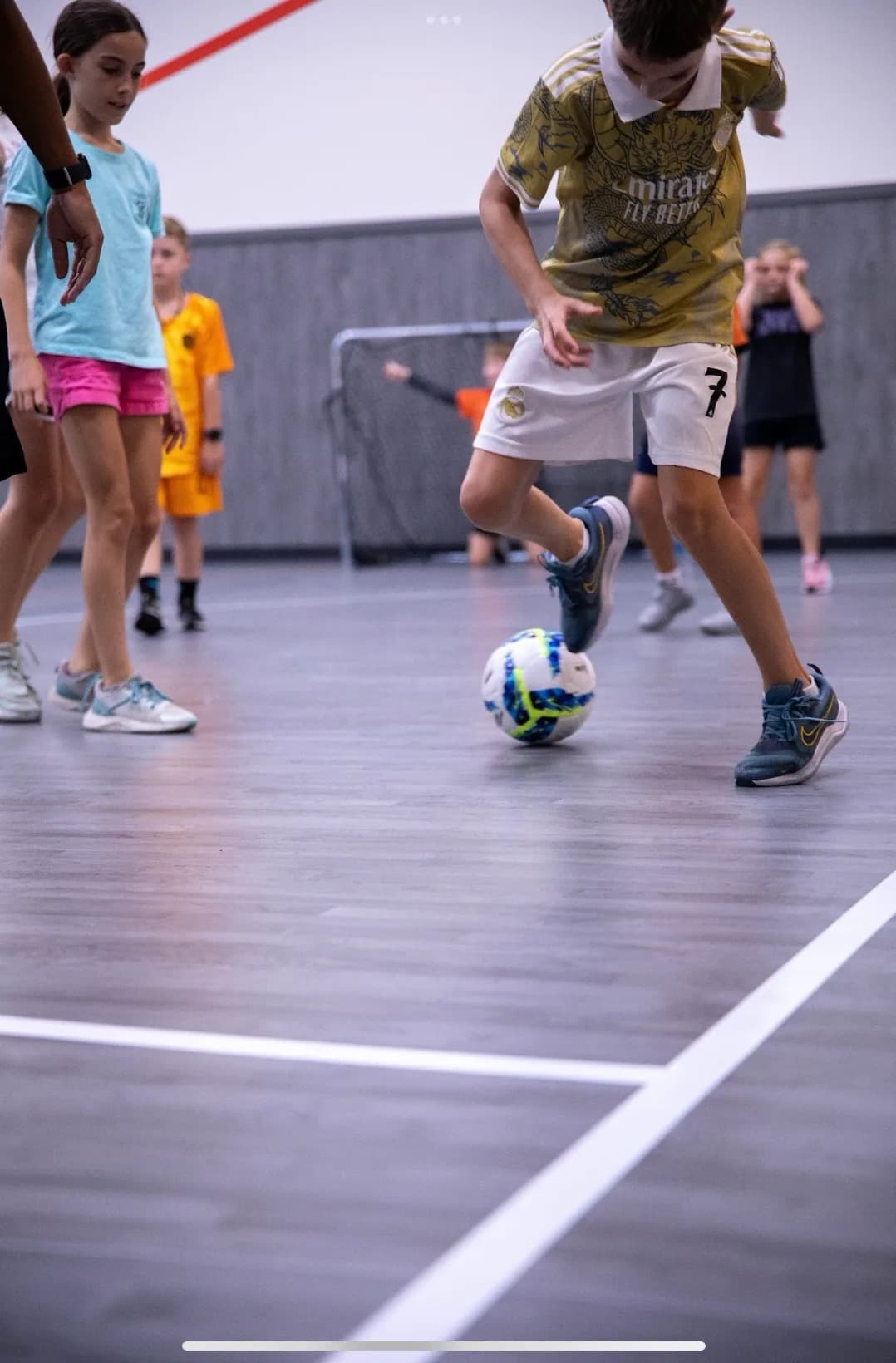 Young players in a futsal scrimmage on the indoor court at Frontrunner Fieldhouse